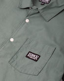 Loser Machine Guadalupe SS Woven Shirt in Green, 100% cotton heavyweight poplin short sleeve workshirt met camp collar engraved pearl buttons patch pocket printed Guadalupe artwork op achterkant straight hem en boxier fit in groene colorway, verkrijgbaar bij Revert 95 Haarlem