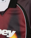 Obey Blurred Soccer Jersey Burnt Red Multi, sportief colorblock shirt van 100% polyester met rib V-hals kraag en Obey screen print, relaxed fit, maten S-XXL, verkrijgbaar bij Revert 95 Haarlem