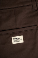 Reell Loose Flex Chino PC broek in Chocolate Brown, loose fit chino van dubbel geverfd polycotton met chino-details en subtiele Reell branding, verkrijgbaar bij Revert 95 Haarlem
