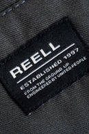 Reell Loose Flex Chino PC broek in Vulcan Grey, loose fit chino van dubbel geverfd polycotton met chino-details en subtiele Reell branding, verkrijgbaar bij Revert 95 Haarlem