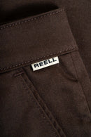 Reell Loose Flex Chino Short PC in Chocolate Brown, 56% katoen 42% polyester 2% elastaan Flex Twill losse rechte chino short met lage kruisnaad verborgen YKK zip-fly zijzakken achterzakken en riemlussen in warme bruine kleur, verkrijgbaar bij Revert 95 Haarlem