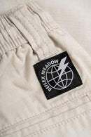 Reell Reflex Meadow broek in Flat White Ripstop, oversized chino-geïnspireerde broek van lichtgewicht ripstop met laag kruis en elastische tailleband, verkrijgbaar bij Revert 95 Haarlem