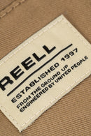 Reell Loose Flex Chino Short PC in Dark Sand, loose fit knielengte short met chino-details, verkrijgbaar bij Revert 95 Haarlem
