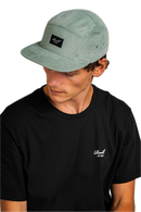 Reell 5-Panel Cap Cord, 100% cotton corduroy relaxed 5-panel snapback met structural brim stitching Reell woven logo patch op voorkant adjustable snapback closure met logo flag en woven brand label verkrijgbaar in Copper Brown Cord Hedge Cord en Black, verkrijgbaar bij Revert 95 Haarlem