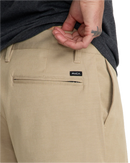 RVCA Back In Hybrid Short in Khaki, 48% cotton 42% polyester 10% elastane 4-way stretch heathered fabric hybrid walkshort met peached finish DWR coating 19 inch outseam zipper fly RVCA button closure side slash pockets en back pocket in warme aardse Khaki colorway, verkrijgbaar bij Revert 95 Haarlem