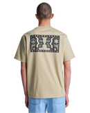 RVCA Face to Face Tee in Khaki, relaxed fit katoenen T-shirt met bold graphic van spiegelende gezichten op de rug en klein borstdetail, verkrijgbaar bij Revert 95 Haarlem