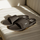 Reef Fanning Slide heren slipper in Black/Silver met verstelbare waterbestendige strap, compression molded EVA voetbed met airbag en ingebouwde flesopener, verkrijgbaar bij Revert 95 Haarlem