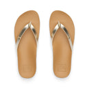 Reef Vista Ivy dames slipper in Golden Hour met PVC-vrij vegan leather twee-band upper, metalen logo detail en gecushioned voetbed, verkrijgbaar bij Revert 95 Haarlem