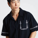 HUF Pinstripe Embroidered Resort Shirt in Black, 100% cotton 150G camp collar short sleeve resort shirt met pinstripe embroidery op linker borstzak zoom en beide mouwen button-down front branded buttons side vent slits en relaxed fit, verkrijgbaar bij Revert 95 Haarlem