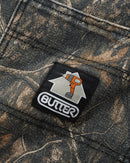 Butter Goods Work Shorts in Forest Camo, 100% cotton canvas baggy fit short met belt loops intern drawstring systeem patch pockets en geweven label in donkergroen militair camouflagepatroon, 63cm outseam op maat 32, verkrijgbaar bij Revert 95 Haarlem
